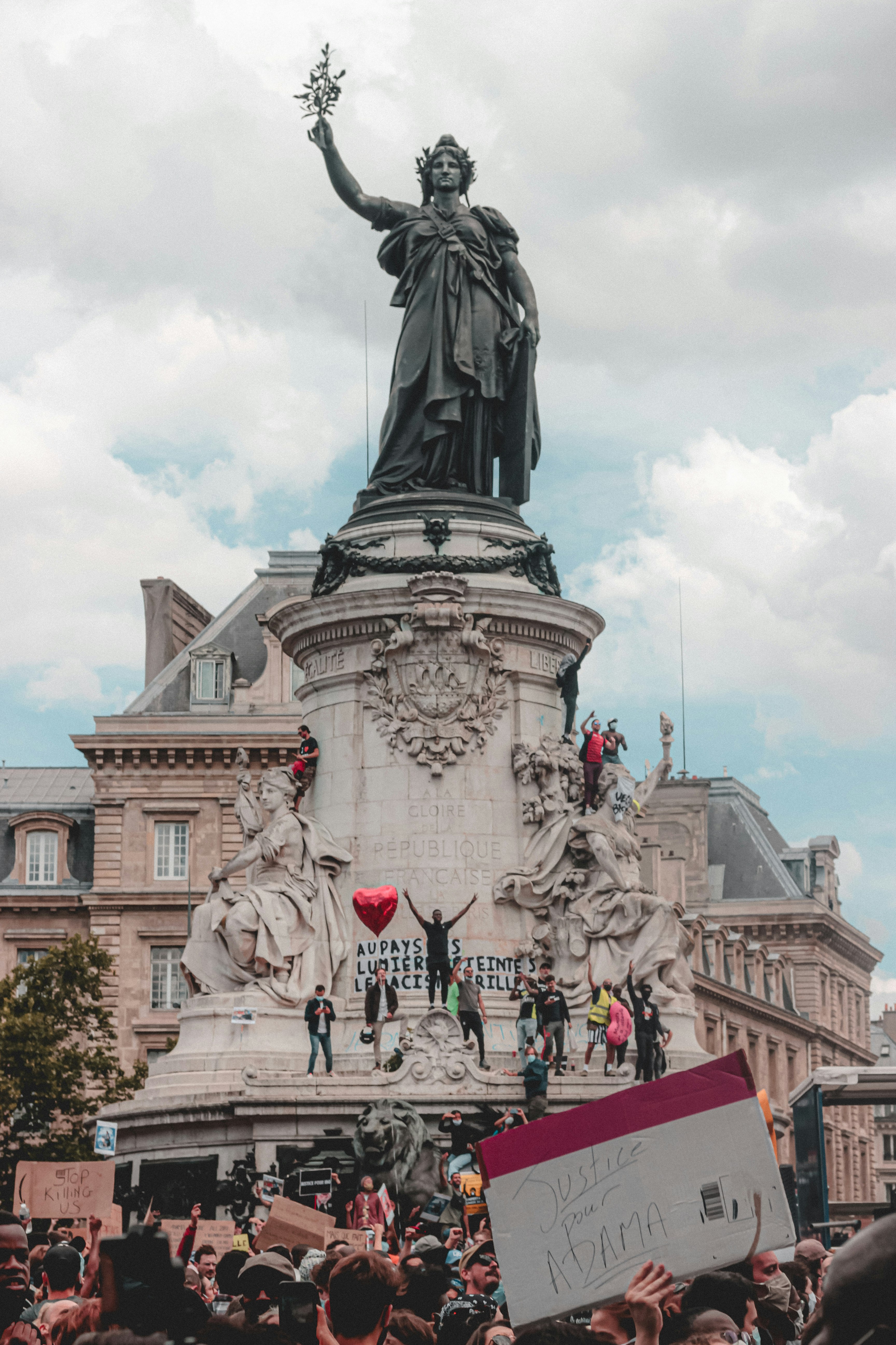 people walking near statue of man riding horse during daytime